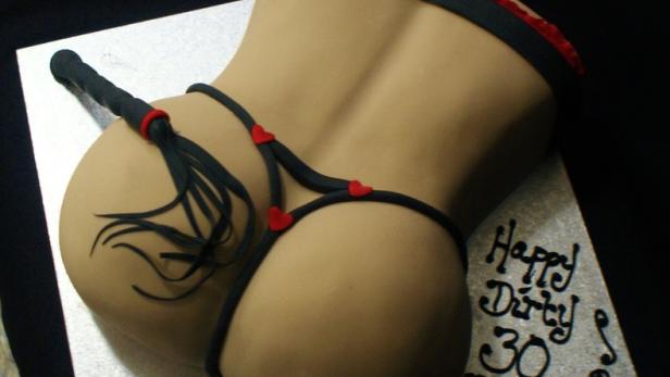 Ein Kuchen in Form eines Frauenkörpers mit Dessous und einer Peitsche, beschriftet mit „Happy Dirty 30 Dale“.