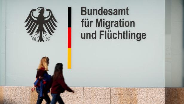 Zwei Personen gehen vor dem Bundesamt für Migration und Flüchtlinge entlang.
