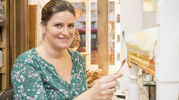 Waltraud Luegger bei der Arbeit in ihrem Atelier „GoldRichtig“. 14 Schritte sind beim Vergolden notwendig. Die Blättchen werden mit Eichkätzschenschweif-Pinseln aufgetragen.