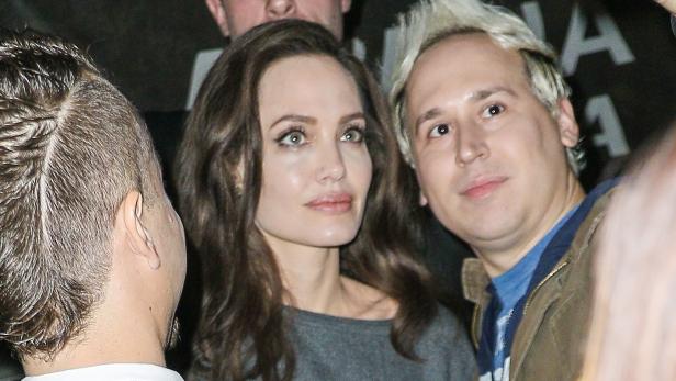 Angelina Jolie umgeben von anderen Personen.