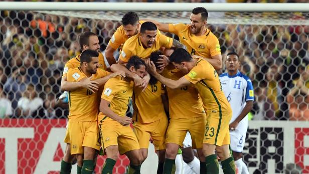 Australia&#039;s Mile Jedinak (C) is mobbed by his teammates after scoring against Honduras during their 2018 World Cup qualification play-off football match at Stadium Australia in Sydney on November 15, 2017. / AFP PHOTO / William WEST / -- IMAGE RESTRICTED TO EDITORIAL USE - STRICTLY NO COMMERCIAL USE --
