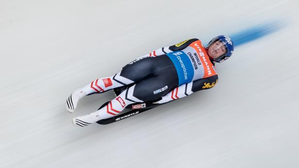Ein Rennrodler rast auf seiner Rodelbahn mit hoher Geschwindigkeit.