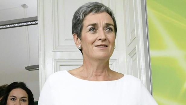 Eine Frau mit kurzem, grauem Haar lächelt.