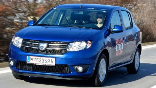 Ein blauer Dacia Sandero fährt auf einer Landstraße.