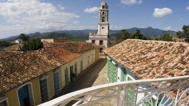 Es ist ein Blick, der den Besucher mit der Hitze und dem schweißtreibenden Besichtigungsprogramm versöhnt: Wie eine Filmkulisse liegt einem hier, auf der Dachterrasse des Kolonialhotels Casagranda, das Panorama der Innenstadt von Santiago de Cuba zu Füßen.