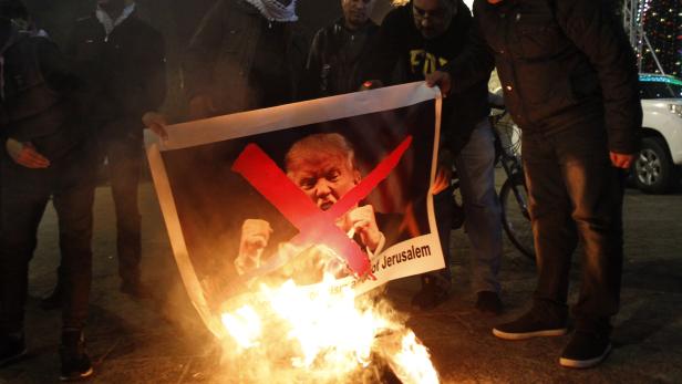 Demonstranten verbrennen ein Foto mit Trumps Konterfei.