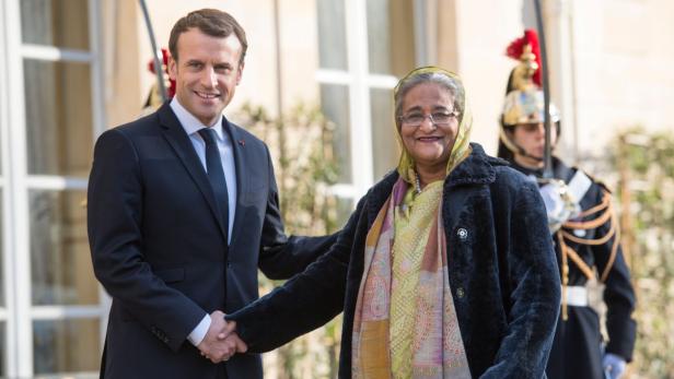 Macron begrüßt Bangladeschs Premierministerin Sheikh Hasina.