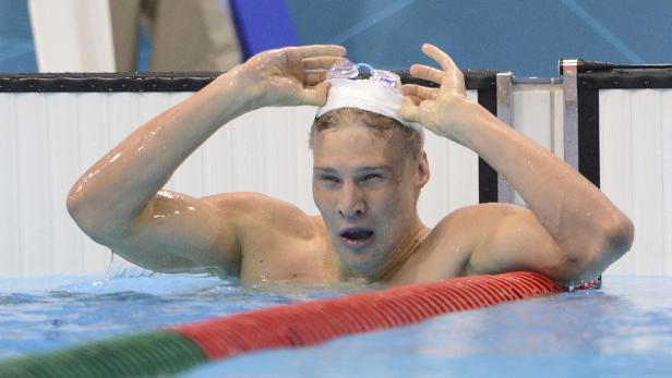 Ein Schwimmer im Schwimmbecken mit Schwimmbrille auf dem Kopf.