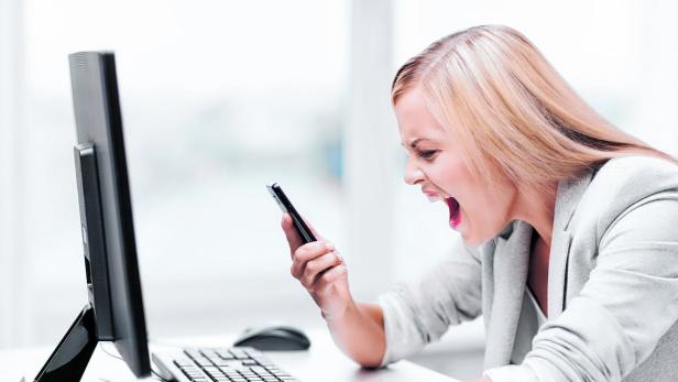 people, business, technology, communication and negative emotion concept - angry woman with smart phone and pc computer screaming curses at office