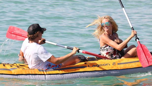 Heidi Klum und ein Mann paddeln in einem gelben Kajak auf dem Wasser.