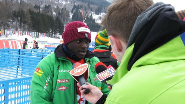 Ein togoischer Sportler wird von Reportern interviewt.