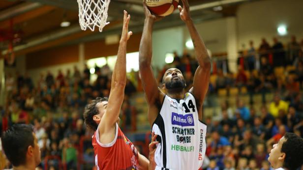 Ein Basketballspieler mit der Nummer 14 wirft den Ball in den Korb.