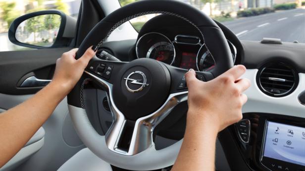 Eine Person fährt ein Auto der Marke Opel.