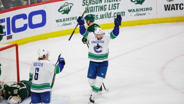 Ein Eishockeyspieler der Vancouver Canucks jubelt mit erhobenen Armen.