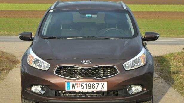 Ein brauner Kia Ceed steht auf einer Straße.