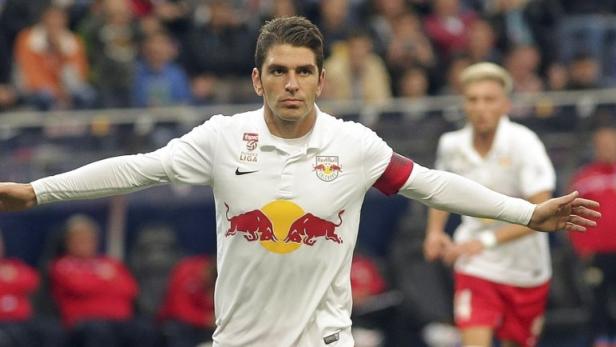 Ein Fußballspieler in weißem Trikot mit dem Red Bull Logo auf dem Spielfeld.