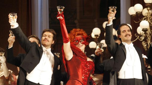 Gäste in Abendgarderobe und Maske stoßen mit Sektgläsern an.