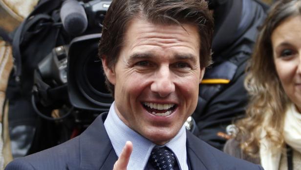 Tom Cruise lächelt vor einer Fernsehkamera.