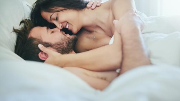 Mann und Frau umarmen sich im Bett