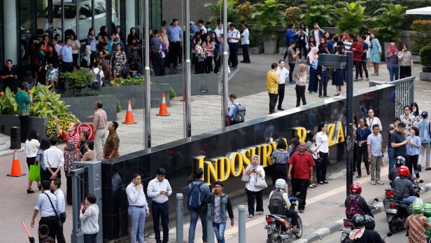 Büroangestellte in Jakarta suchen Schutz unter freiem Himmel.