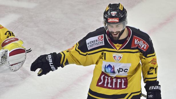 Ein Eishockeyspieler in gelb-schwarzer Spielkleidung jubelt auf dem Eis.