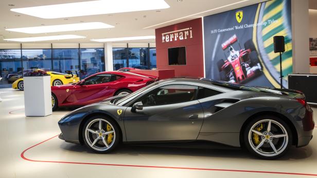 Ein grauer Ferrari steht in einem Ausstellungsraum.