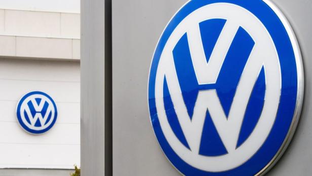Das blaue und weiße Volkswagen-Logo an einem Gebäude.