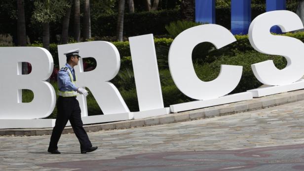 Kopie von A traffic policeman walks past a signage for BRICS