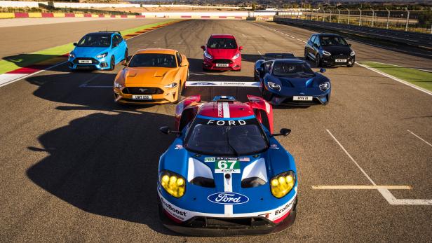 Mehrere Ford-Fahrzeuge, darunter ein Ford GT Rennwagen, stehen auf einer Rennstrecke.