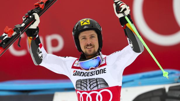 Marcel Hirscher feiert mit Skiern und Stöcken in der Luft.