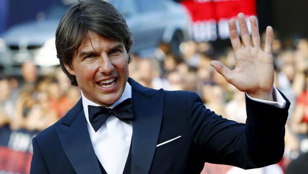 Tom Cruise winkt den begeisterten Fans vor der Staatsoper zu.