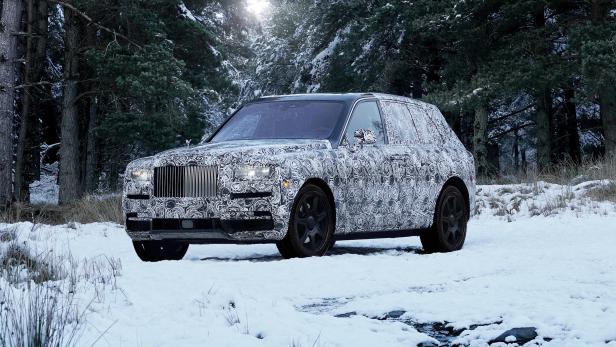 Ein mit einem Musterdesign versehener Rolls-Royce steht im Schnee vor einem Wald.