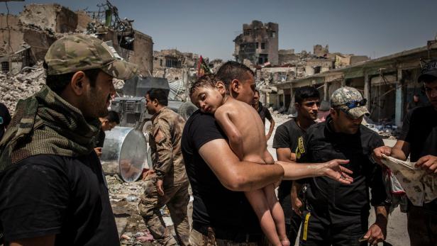 Nominiert für das World Press Foto 2018: Irakische Spezialeinheiten versorgen einen unbekannten Jungen, der von einem mutmaßlichen Militanten aus dem Kriegsgebiet um Mossul getragen wurde. Der Mann hatte das Kind wahrscheinlich als Schutzschild benützt.