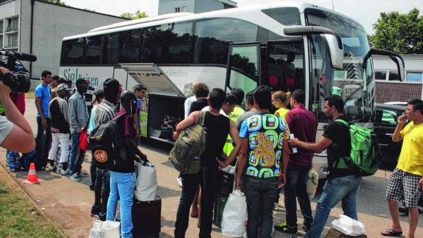Mit Bussen wurden 74 Flüchtlinge vom Polizeisportplatz in die Berufsschule Turmstraße gebracht. 66 Asylwerber müssen noch in Zelten und im Turnsaal ausharren (re.)