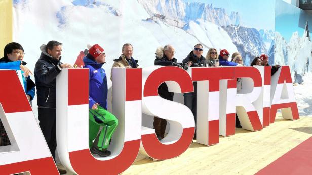 Menschen stehen hinter Buchstaben die Österreich auf Englisch bedeuten