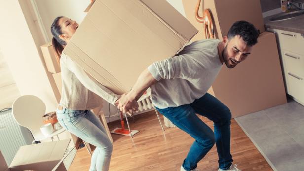 Stock-Fotografie-ID:529672832 Young couple carrying big cardboard box at new home.Moving house.