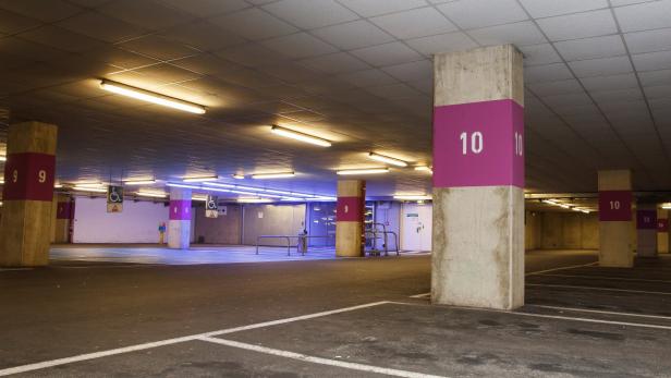 Eine leere Tiefgarage mit nummerierten Stellplätzen und Behindertenparkplätzen.