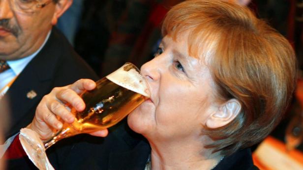 Angela Merkel trinkt ein Glas Bier.