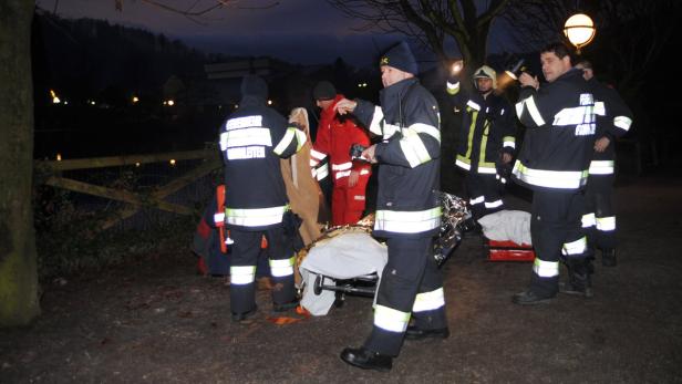 Einsatzkräfte der Feuerwehr kümmern sich um eine Person auf einer Trage.