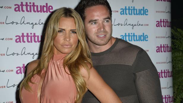 Katie Price und Kieran Hayler posieren auf einer Veranstaltung vor einer Wand mit Logos.