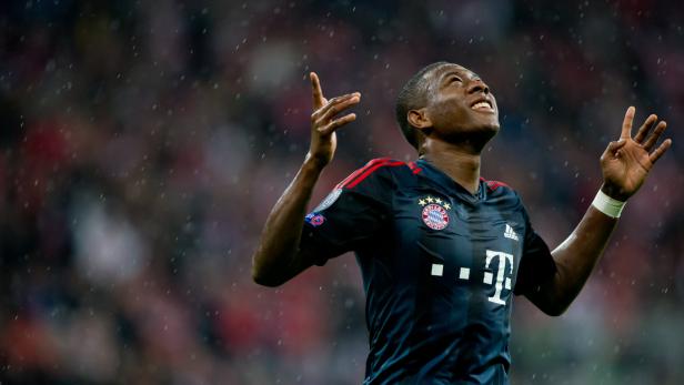 David Alaba jubelt im Regen im Trikot des FC Bayern München.