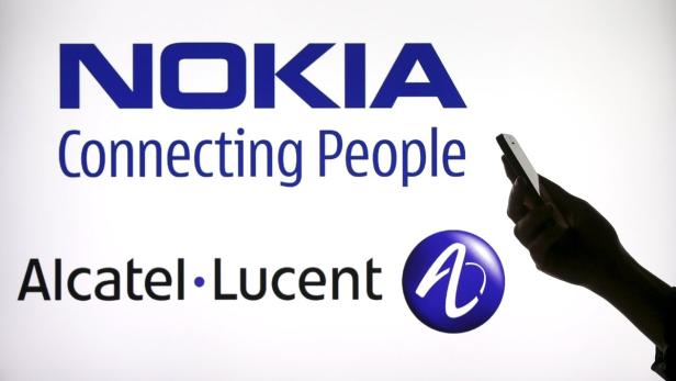 Photo illustration of a woman holding a smartphone Nokia: Grünes Licht für Alcatel-Lucent-Übernahme