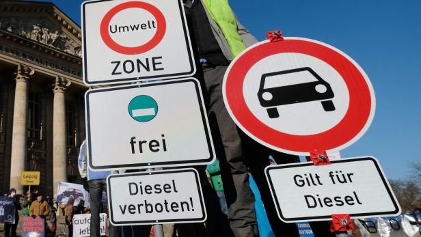 An environmental activist demonstrates with street signs on February 22, 2018 in front of the Federal Administrative Court in Leipzig, eastern Germany, where the court possibly will deliver a verdict on the legality of banning driving diesel cars when pollution reaches high levels. Since Volkswagen admitted in 2015 to installing software to fool regulatory emissions tests in millions of cars worldwide -- the so-called &quot;dieselgate&quot; scandal -- nitrogen oxide (NOx) and fine particle emissions from diesel motors have been the top priority for German environmentalists. / AFP PHOTO / dpa / Sebastian Willnow / Germany OUT