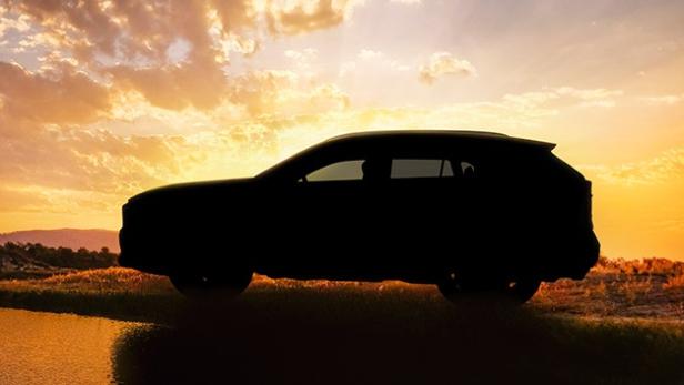 Die Silhouette eines Autos vor einem Sonnenuntergang.