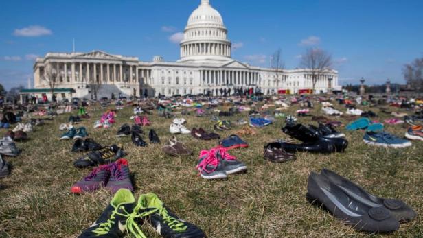 TOPSHOT - The lawn outside the US Capitol is covered with 7,000 pairs of empty shoes to memorialize the 7,000 children killed by gun violence since the Sandy Hook school shooting, in a display organized by the global advocacy group Avaaz, in Washington, DC, March 13, 2018. / AFP PHOTO / SAUL LOEB