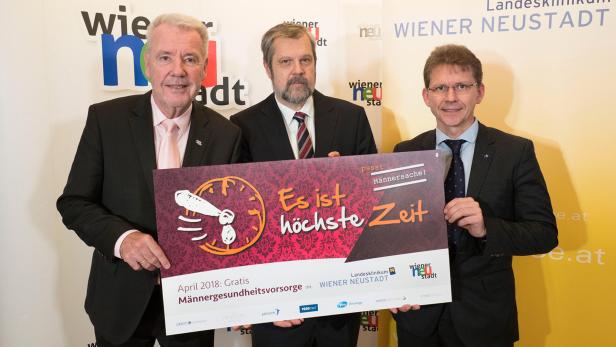 Drei Männer halten ein Schild mit der Aufschrift „Es ist höchste Zeit“ für eine Männergesundheitsvorsorge in Wiener Neustadt.