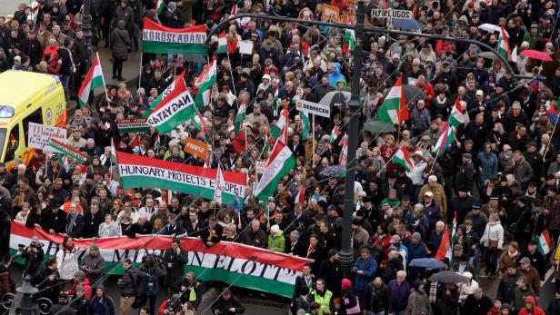 People supporting the government of Hungary&#039;s Prime Minister carry flags in the colors of their country as they take part in a &quot;Peace March&quot; in Budapest on March 15, 2018, as celebrations are under way to commemorate the 170th anniversary of the 1848-1849 Hungarian revolution and independence war on Hungary&#039;s National Day. Hungarians took to the streets in separate national day demonstrations to both voice support for, and protest against, Prime Minister Viktor Orban, as an election April 8, 2018 nears. / AFP PHOTO / Peter Kohalmi