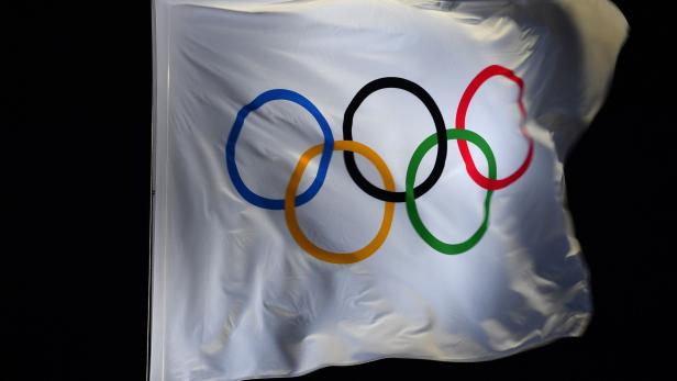 The Olympic flag bearing the Olympic rings flutters at the Pyeongchang Medals Plaza during the Pyeongchang 2018 Winter Olympic Games in Pyeongchang on February 12, 2018. / AFP PHOTO / Fabrice COFFRINI