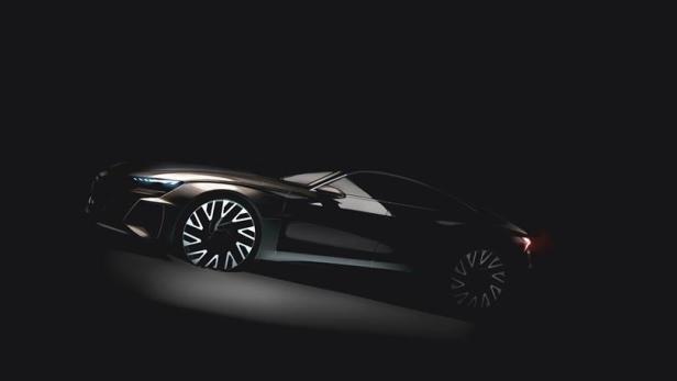 Ein dunkles Auto mit futuristischen Felgen steht im Schatten.