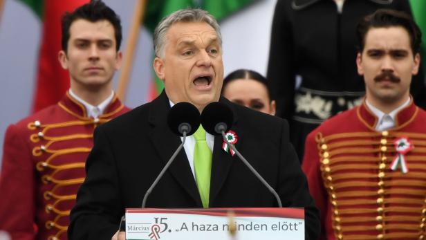 Hungarian Prime Minister Viktor Orban delivers a speech in front of the building of the Hungarian Parliament in Budapest on March 15, 2018, during the official commemoration of the 170th anniversary of the 1848-1849 Hungarian revolution. Tens of thousands of Hungarians took to the streets Thursday in separate national day demonstrations to both voice support for, and protest against, Prime Minister Viktor Orban, as an election April 8 nears. / AFP PHOTO / Attila KISBENEDEK